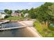 A waterfront backyard features a private beach, boat dock, lush lawn and mature trees at 22501 John Gamble Rd, Cornelius, NC 28031