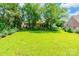 Grassy backyard offering a private retreat, bordered by mature trees and shrubs at 2363 Sanderling Dr, Rock Hill, SC 29732