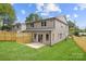 Backyard featuring a wood fence, green lawn, and patio, complete with a two-story home in the background at 2413 Pruitt St, Charlotte, NC 28208