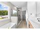 Bright bathroom with a large glass shower and soaking tub by the window at 2413 Pruitt St, Charlotte, NC 28208