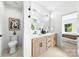 Modern bathroom with a double vanity and light wood cabinets with matte black hardware at 2413 Pruitt St, Charlotte, NC 28208