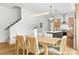 Bright dining room with a table set for six, modern light fixtures, and an open view of the kitchen at 2413 Pruitt St, Charlotte, NC 28208