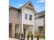 Exterior view of modern townhomes with unique design elements, a shared driveway, and manicured landscaping at 2413 Pruitt St, Charlotte, NC 28208