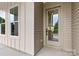 Exterior view of a beige home's front door and window, showcasing the home's facade and natural light at 2413 Pruitt St, Charlotte, NC 28208