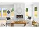 Bright and cozy living room featuring a decorative fireplace, large windows, and comfortable seating at 2413 Pruitt St, Charlotte, NC 28208