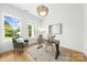 Bright home office featuring a modern desk, comfortable seating, and natural light from two large windows at 2413 Pruitt St, Charlotte, NC 28208