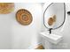 Modern powder room features a white pedestal sink and decorative woven baskets at 2413 Pruitt St, Charlotte, NC 28208