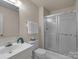 Bathroom features shower with sliding glass doors, vanity with ample counter space, and bright walls at 2419 Quail Lake Dr, Charlotte, NC 28210