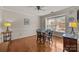 Bright dining area featuring a round table, wood floors, a ceiling fan, and large windows that fill the space with natural light at 2419 Quail Lake Dr, Charlotte, NC 28210