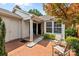 Charming home featuring a red brick patio with seating, manicured landscaping, and natural light at 2419 Quail Lake Dr, Charlotte, NC 28210