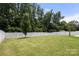 A spacious backyard featuring a lush green lawn, a privacy fence, and mature trees providing shade and seclusion at 2448 Sweet Birch Ct, Gastonia, NC 28054