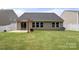 A well-maintained backyard featuring a patio, lawn, and the home's exterior with multiple windows at 2448 Sweet Birch Ct, Gastonia, NC 28054