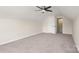 Bonus room features neutral walls, plush carpet, and a ceiling fan; doorway leads to additional storage at 2448 Sweet Birch Ct, Gastonia, NC 28054