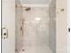 Elegant walk-in shower with white marble-style tile, and gold fixtures, including a rainfall shower head at 2448 Sweet Birch Ct, Gastonia, NC 28054