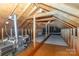 Spacious attic with wooden beams, lighting, and ample room for storage or future expansion at 2627 Willis Dr, Harrisburg, NC 28075