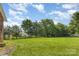 Expansive backyard with lush green grass, mature trees, and well-maintained landscaping at 2627 Willis Dr, Harrisburg, NC 28075