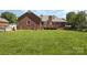 Expansive backyard featuring a brick house, well-maintained lawn, and inviting deck for outdoor enjoyment at 2627 Willis Dr, Harrisburg, NC 28075