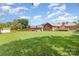 Expansive backyard featuring a brick house, wooden deck, garden, storage shed, and mature trees at 2627 Willis Dr, Harrisburg, NC 28075