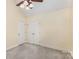 Spacious bedroom features plush carpet, ceiling fan, two entry doors and a closet at 2627 Willis Dr, Harrisburg, NC 28075