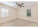 Neutral bedroom featuring plush carpet, two windows, and a ceiling fan at 2627 Willis Dr, Harrisburg, NC 28075