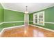 Bright dining room with green walls, hardwood floors, and classic chandelier at 2627 Willis Dr, Harrisburg, NC 28075