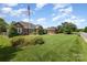 Beautiful brick home with an American flag, lush green lawn, and well-maintained landscaping at 2627 Willis Dr, Harrisburg, NC 28075