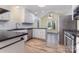 Well-lit kitchen with white cabinets, stainless appliances, and eat-in breakfast area at 2627 Willis Dr, Harrisburg, NC 28075