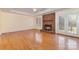 Bright living room with hardwood floors, a brick fireplace, and French doors leading to the backyard at 2627 Willis Dr, Harrisburg, NC 28075