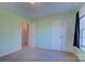 Light green bedroom featuring neutral carpet, natural light, closet, and an open doorway at 2712 Thornburg Ct, Monroe, NC 28110