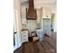 Kitchen area featuring wooden range hood, white cabinets, and new flooring at 3000 Paul Payne Store Rd, Taylorsville, NC 28681