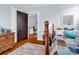 Light-filled bedroom featuring hardwood floors, colorful quilt, and view into the hallway at 329 E Congress St, Lincolnton, NC 28092