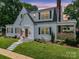 Charming two-story home with white siding, black shutters, an American flag and manicured lawn at dusk at 329 E Congress St, Lincolnton, NC 28092