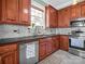 Well-lit kitchen featuring stainless steel appliances, double basin sink, granite counters, and wooden cabinets at 329 E Congress St, Lincolnton, NC 28092