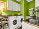 Bright laundry room features front load washer, dryer and ample storage at 329 E Congress St, Lincolnton, NC 28092