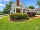 Charming home featuring a side porch framed by a brick pathway and manicured shrubbery at 329 E Congress St, Lincolnton, NC 28092