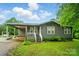 View of the home featuring a cozy front porch, covered parking, mature landscaping, and a well-manicured lawn at 3810 Biggers Rd, York, SC 29745