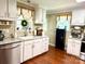 Well-lit kitchen featuring white cabinets, a stainless steel dishwasher, and hardwood floors at 3810 Biggers Rd, York, SC 29745
