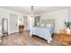 A bright bedroom features wood floors, multiple closets and doors, and light blue accents in the bed linens at 400 S Westover Dr, Monroe, NC 28112