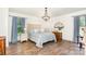 A bright, airy bedroom with beautiful wood floors, a decorative chandelier, and blue accents in the linens at 400 S Westover Dr, Monroe, NC 28112