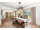 Bright dining room featuring an ornate light fixture, wood floors, and a large dark wood table with bench seating at 400 S Westover Dr, Monroe, NC 28112