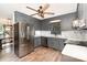 Gray kitchen featuring updated stainless appliances, a wood ceiling fan, marble backsplash, and plank flooring at 400 S Westover Dr, Monroe, NC 28112