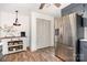 Gray cabinets, stainless refrigerator, and kitchen island with seating and shelving accent this eat-in kitchen at 400 S Westover Dr, Monroe, NC 28112