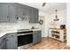A cozy kitchen with gray cabinets and stainless steel appliances, plus an island with wicker baskets for storage at 400 S Westover Dr, Monroe, NC 28112