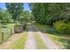 Gravel driveway leading through a gated entrance, offering a secluded and private approach to the property at 4026 Biggerstaff Rd, Maiden, NC 28650