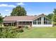 Exterior home view, displaying a deck with stairs, a glass conservatory, and lush landscaping at 4026 Biggerstaff Rd, Maiden, NC 28650