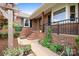 Inviting brick home entrance, featuring a cozy porch with flower embellishments and well-kept landscaping at 4026 Biggerstaff Rd, Maiden, NC 28650