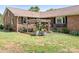 Brick house with an eye-catching pergola. The garden is full of colorful blooms and lush greenery at 4026 Biggerstaff Rd, Maiden, NC 28650
