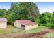 Exterior view of a wooden outbuilding and grass lawn surrounded by trees at 4026 Biggerstaff Rd, Maiden, NC 28650