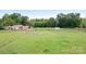 Wide shot showing an expansive green field, fenced in areas and various outbuildings at 4026 Biggerstaff Rd, Maiden, NC 28650