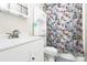 Cozy bathroom showcasing a white vanity and a shower with a decorative floral curtain at 4104 Pebblebrook Sw Cir, Concord, NC 28027